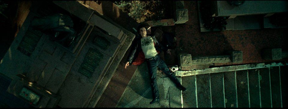 A man is laying on the ground in a dark room.