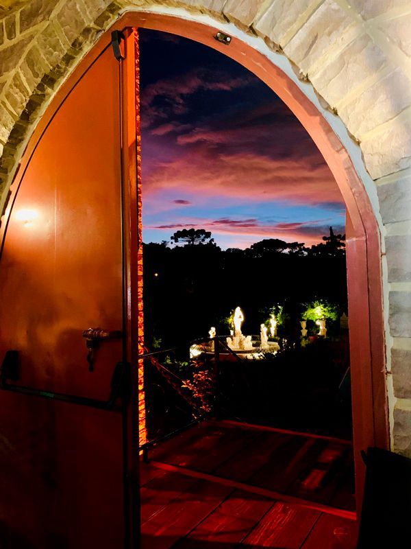A door is open to a cemetery with a sunset in the background