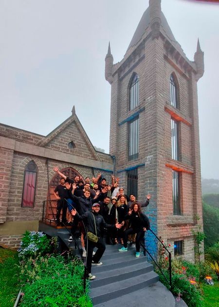 A group of people are posing for a picture in front of a brick building.