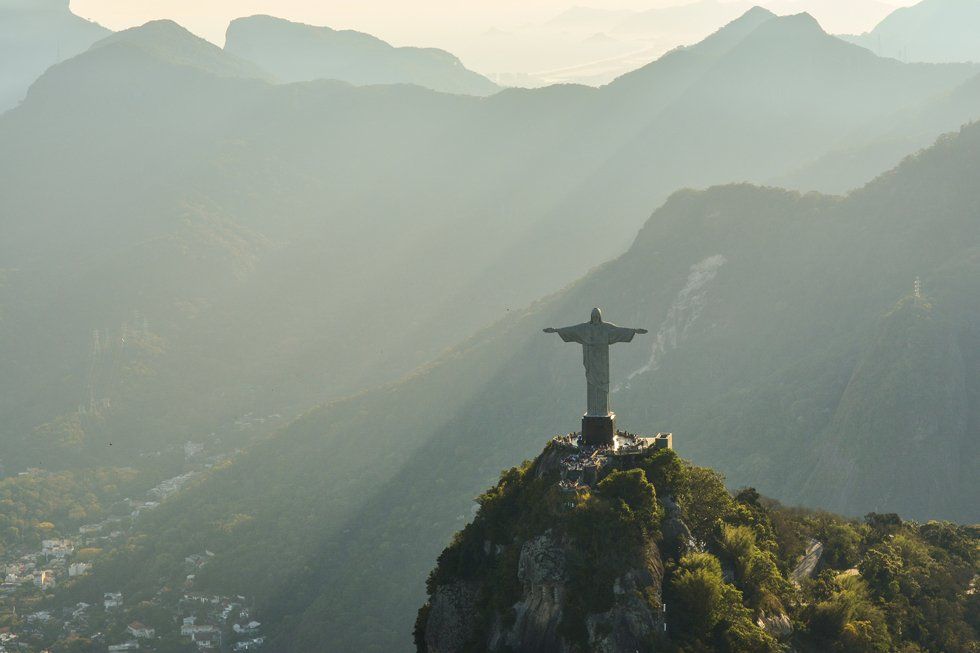 There is a statue of jesus on top of a mountain.