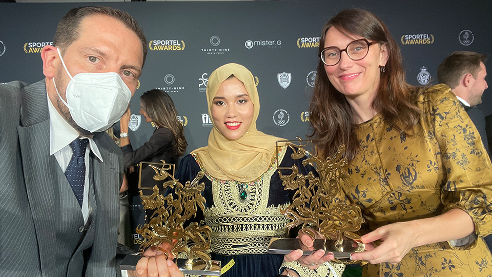 Nick Story holds the Sportel award along with two women