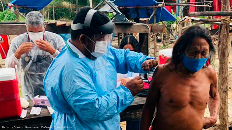 A man is getting a vaccine from a doctor while wearing a mask.