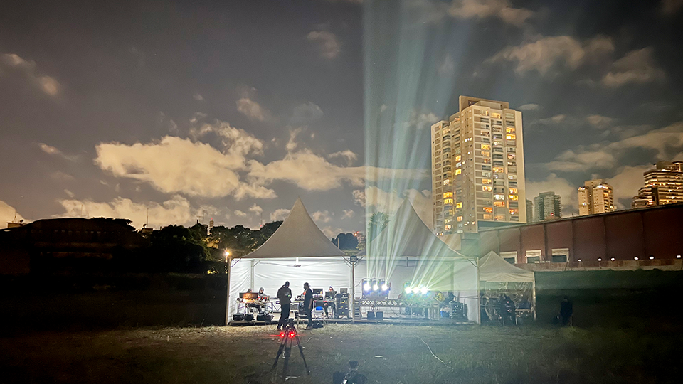 A panoramic view on a coffee farm in rural Brazil A group of people are standing in front of a tent in a field at night.