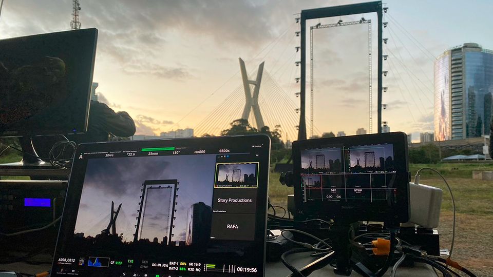 A view of the fields on a coffee farm in rural Brazil A laptop computer is sitting on a table next to a camera.