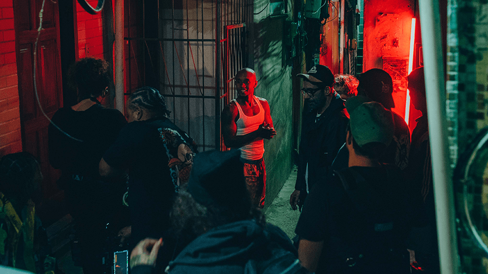 A group of people are standing in a dark alleyway.