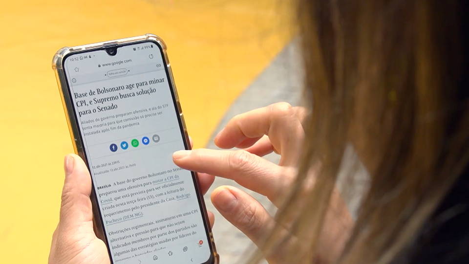 A woman is holding a cell phone in her hand.