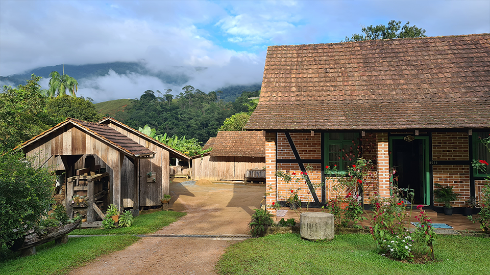 A brick house with a wooden shed in front of it.