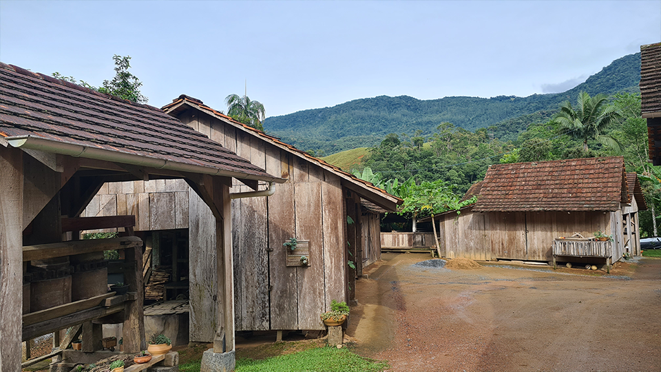A group of wooden buildings with mountains in the background.