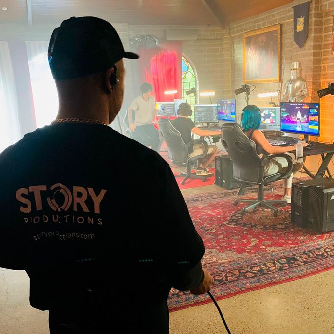 A man wearing a black shirt that says story productions is standing in a room.