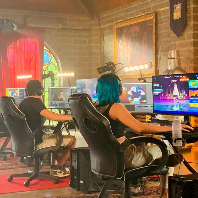 A woman with blue hair is playing a video game