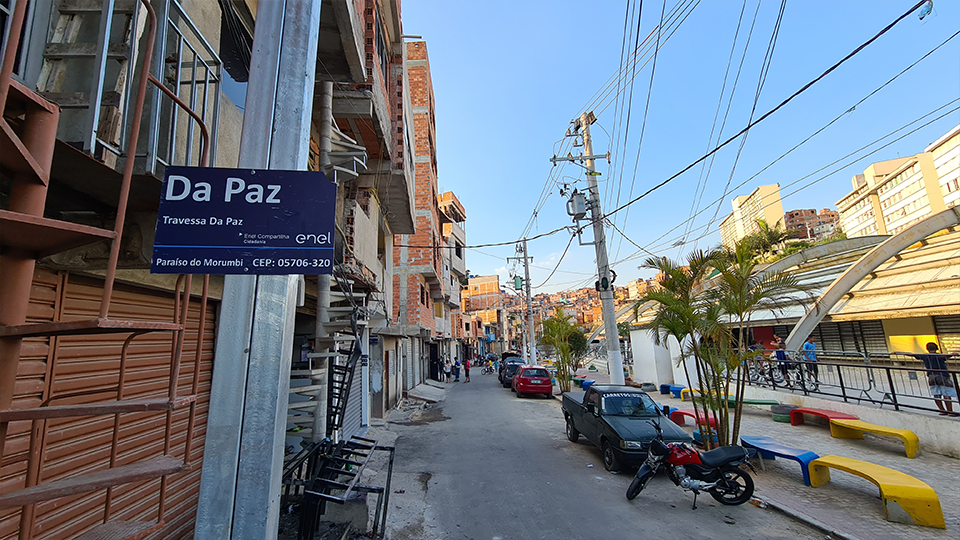 An view of a street with pedestrian walking, motocycles parked in broad daylight