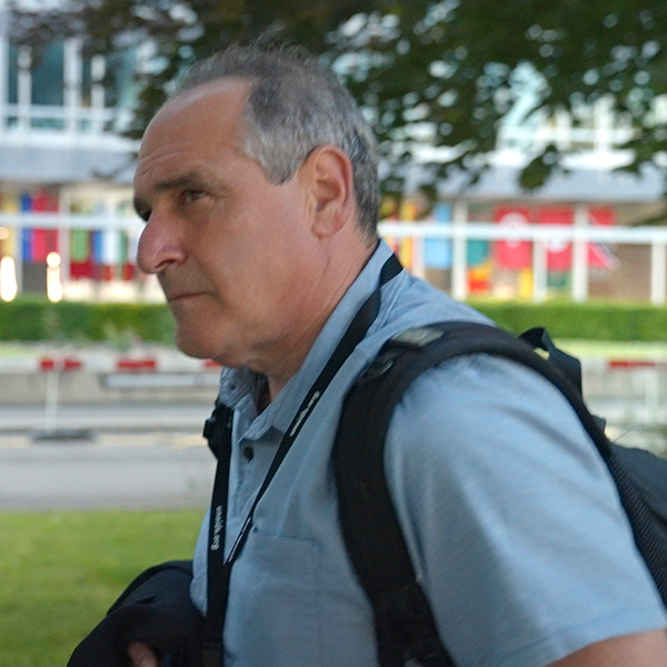 A man wearing a lanyard that says ' nikon ' on it