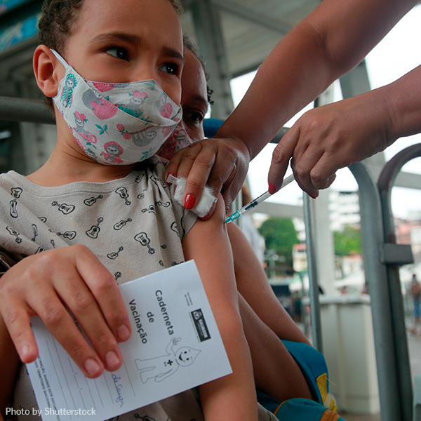 A child wearing a mask is getting a vaccine