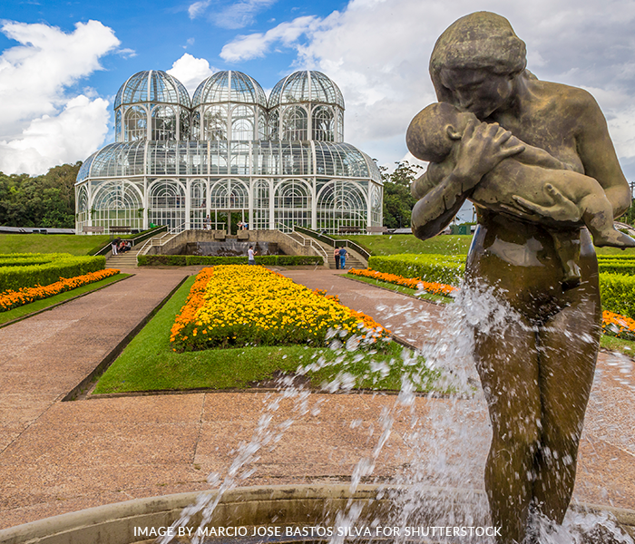 A statue of a woman holding a baby in front of a building