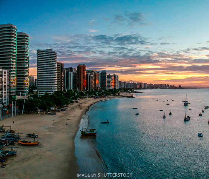 An aerial view of a city and a beach at sunset.