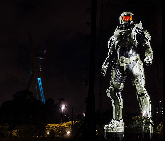 A statue of a man in a military uniform is lit up at night