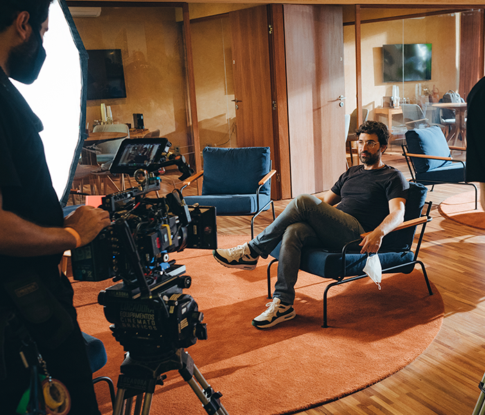 A man is sitting in a chair in front of a camera
