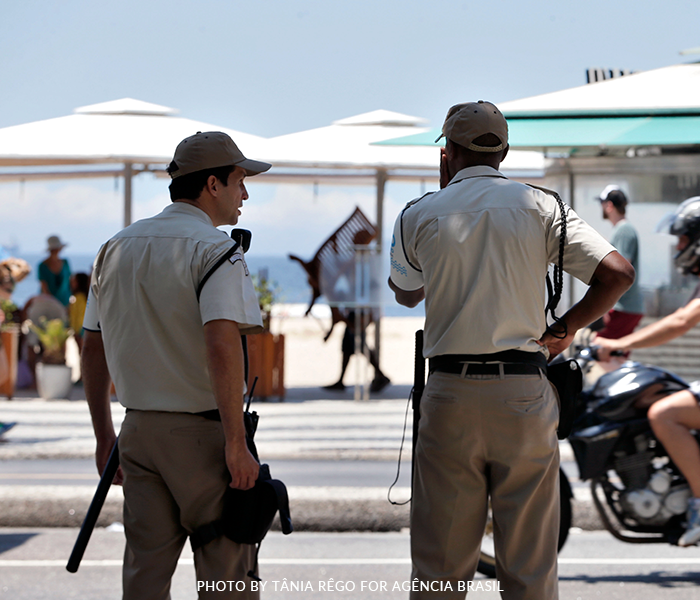 Two police officers are standing on the side of the road looking at something