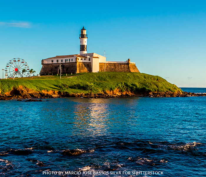 A lighthouse on a small island in the middle of the ocean