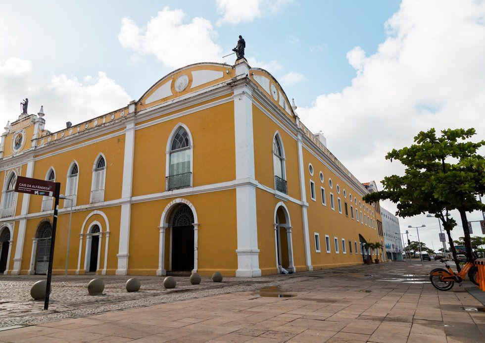 A large yellow building with a statue on top of it