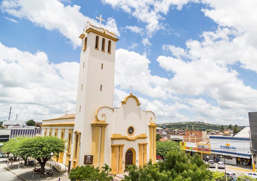 An aerial view of a church with a tower and a cross on top of it.