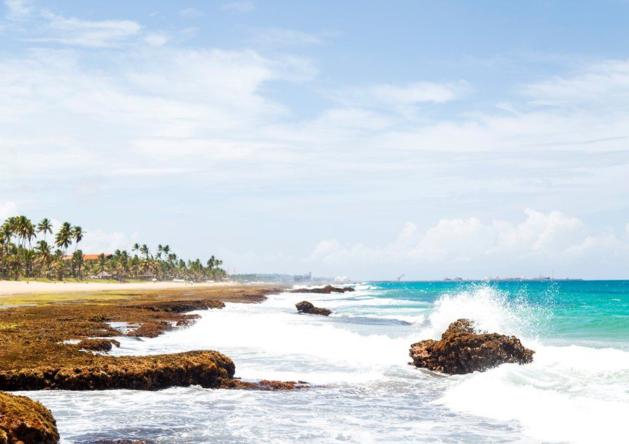 The waves are crashing against the rocks on the beach.