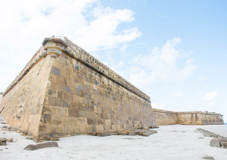 A large stone wall with a blue sky in the background