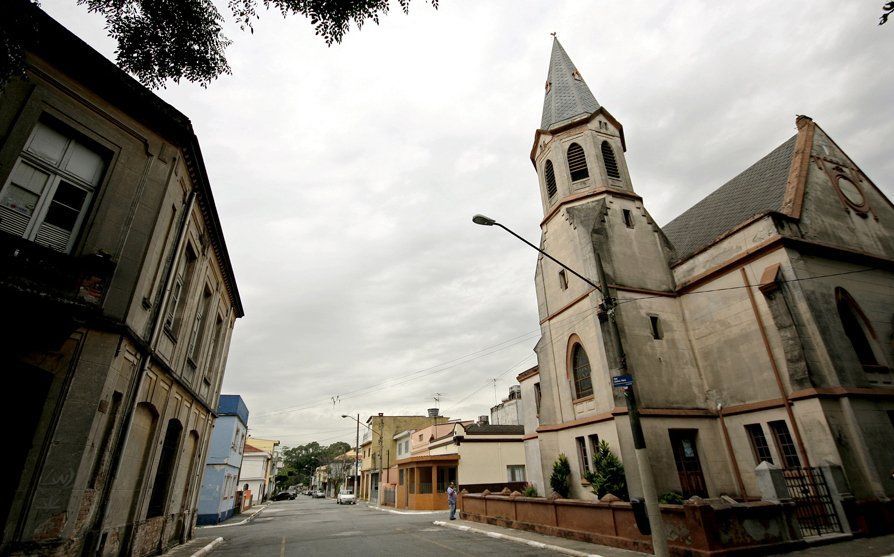 A church with a steeple in the middle of a street