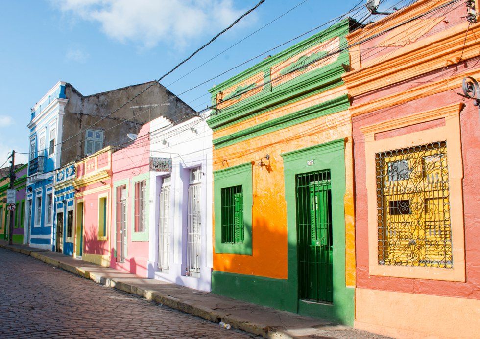 A row of colorful houses on a cobblestone street.