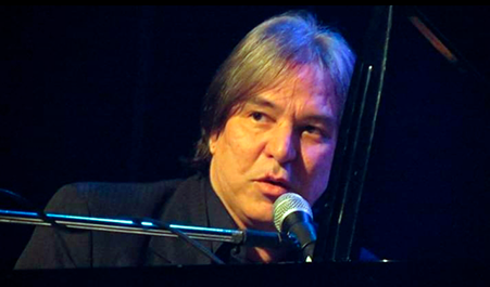 Muscisian Rafael Righini speaks to a microphone