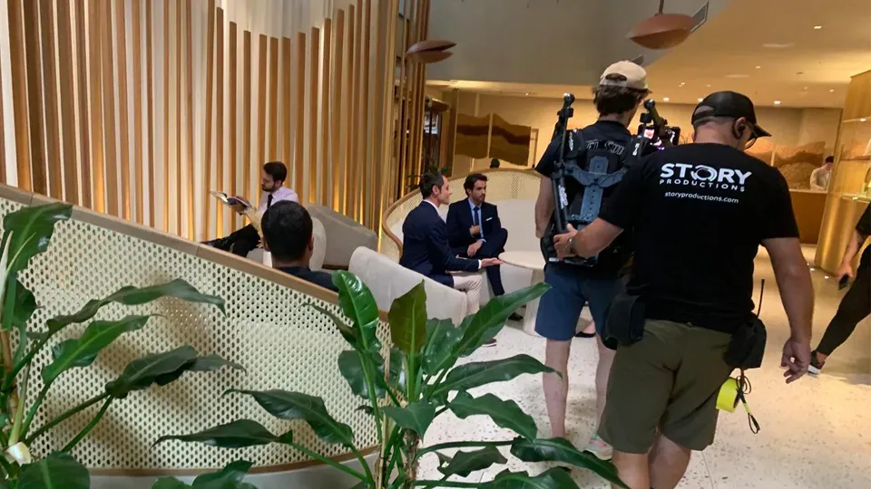 A group of people are standing in a room talking to each other.