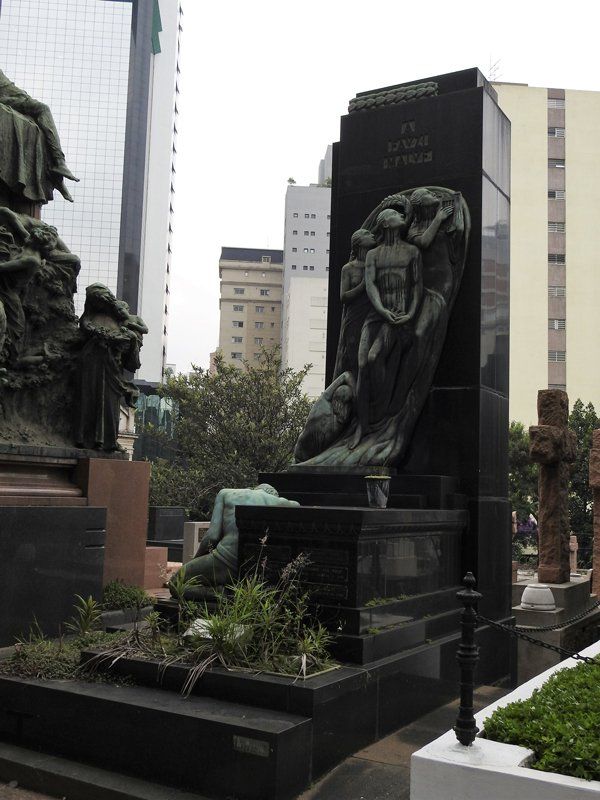 A cemetery with a statue of a woman laying on the ground