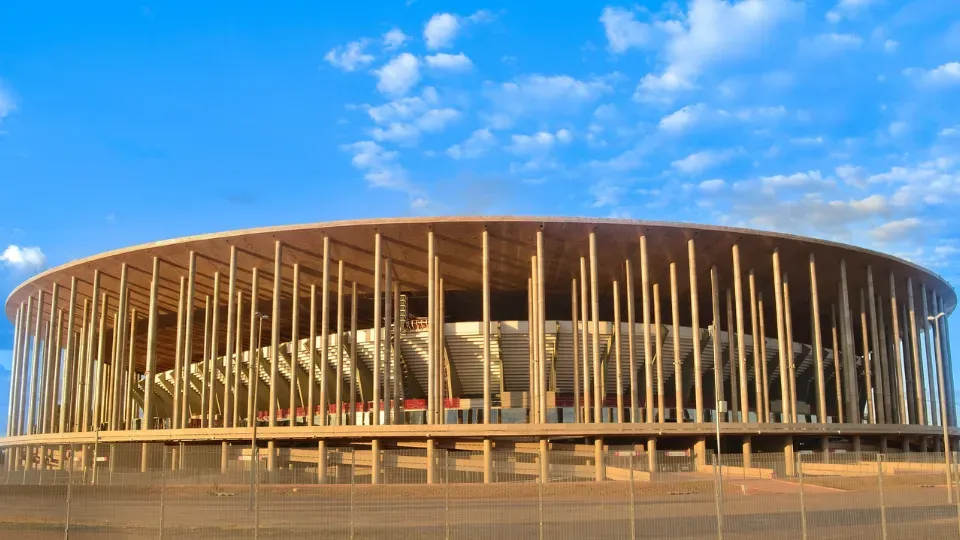 A large wooden stadium with a blue sky in the background.