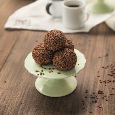 A plate of chocolate balls on a wooden table