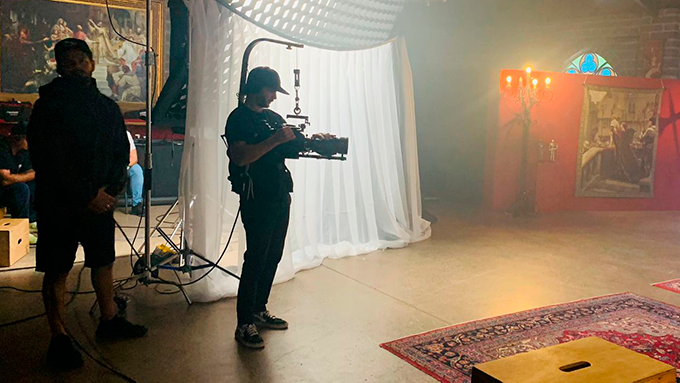 A man is standing in front of a camera in a room.