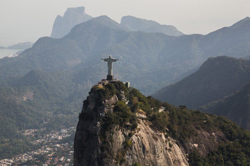 Dramatic arial view of the statue of Cristo Redentor Statue on top of a the Corcovado mountain, dominating Rio de Janeiro.