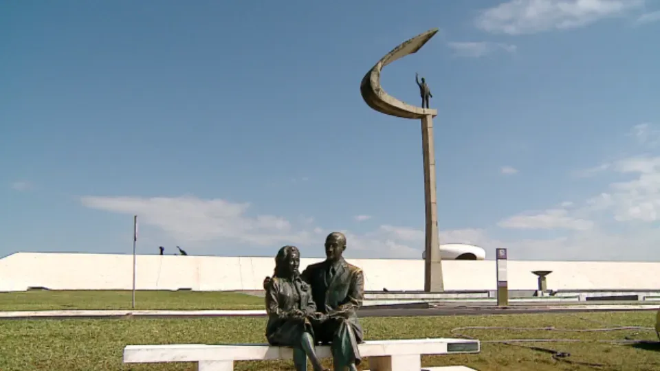 A statue of a man and woman sitting on a bench