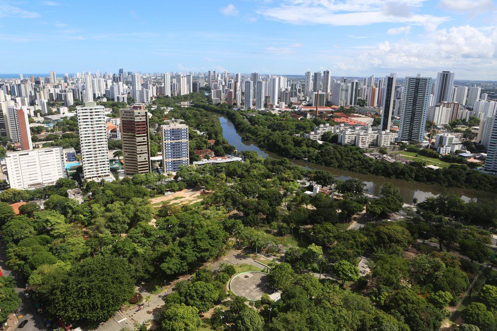 An aerial view of a city with a river running through it and a park in the foreground.
