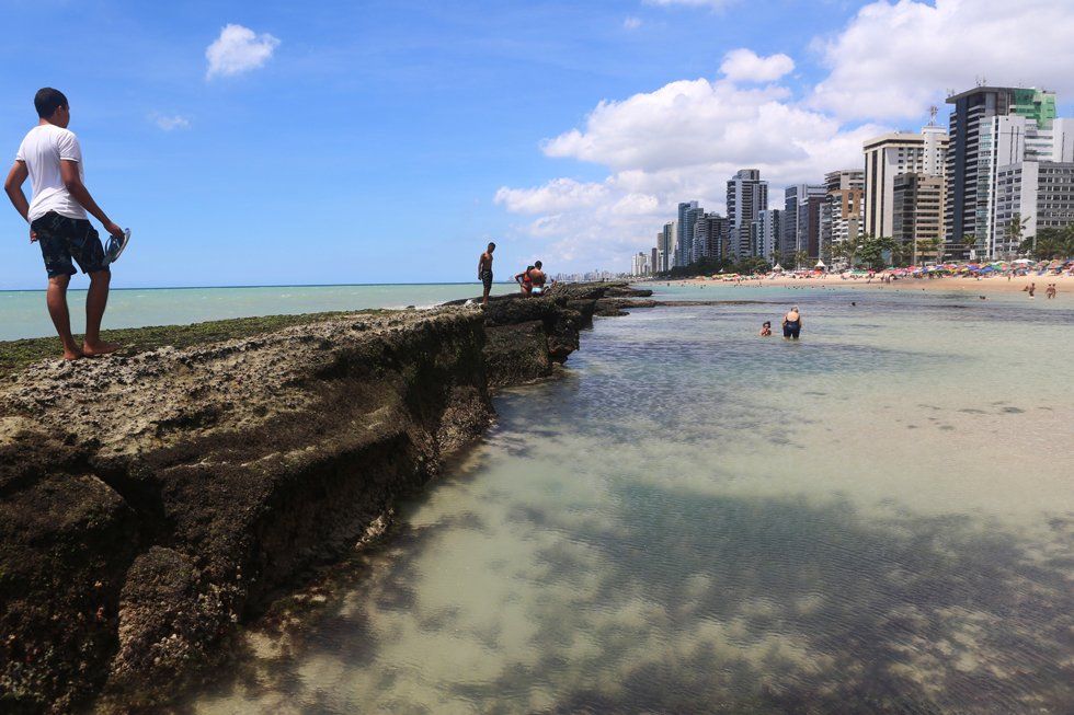A man standing on a rock overlooking a body of water
