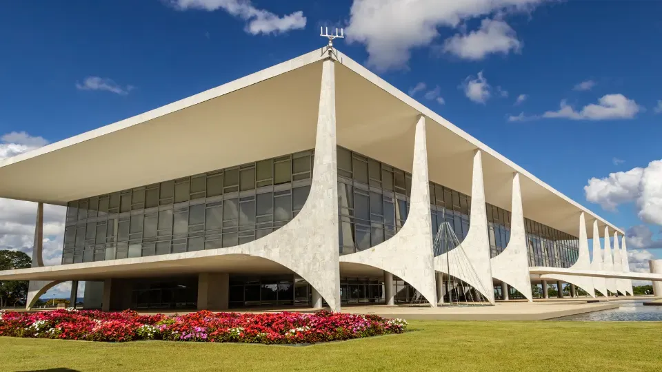 A large white building with columns and a blue sky in the background.