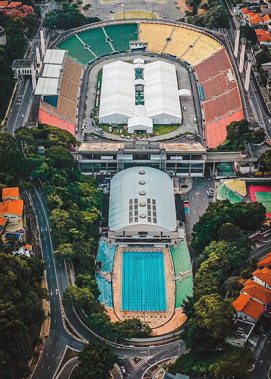 An aerial view of a large stadium with a swimming pool in the middle of it.