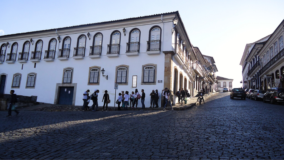A group of people standing in front of a large white building