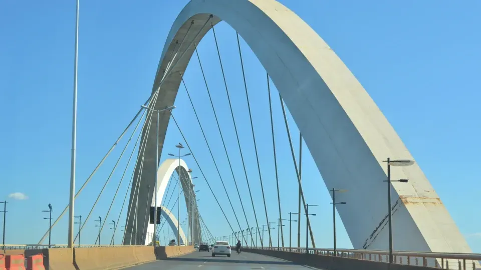 A white bridge with a blue sky in the background
