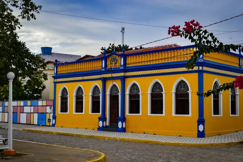 A yellow building with blue trim and arched windows