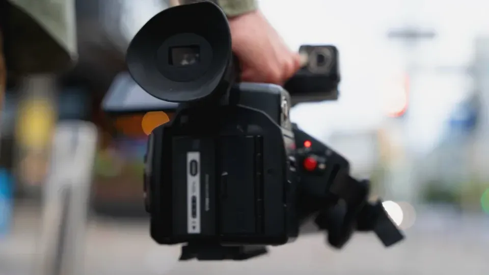 A person is holding a video camera in their hand.