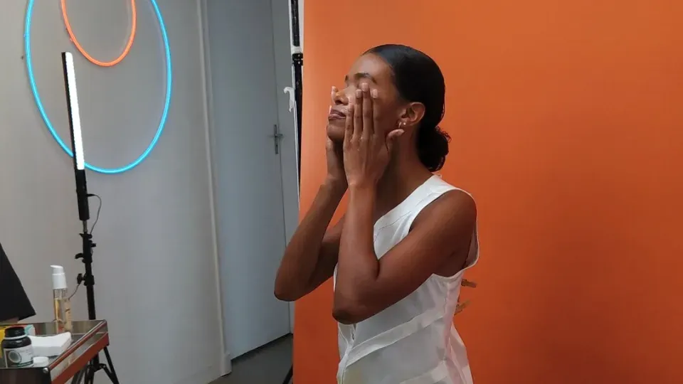 person with black skin being recorded while doing skincare