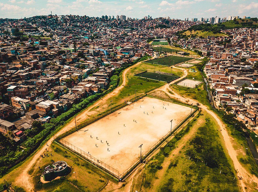 An aerial view of a soccer field with a city in the background.