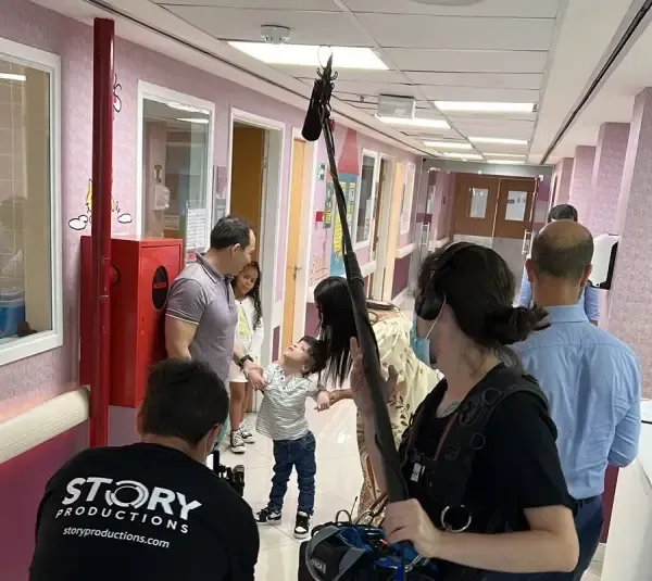 A group of people standing in a hallway with a man wearing a black shirt that says story productions