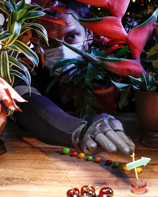 A man wearing a mask and gloves is playing with candy