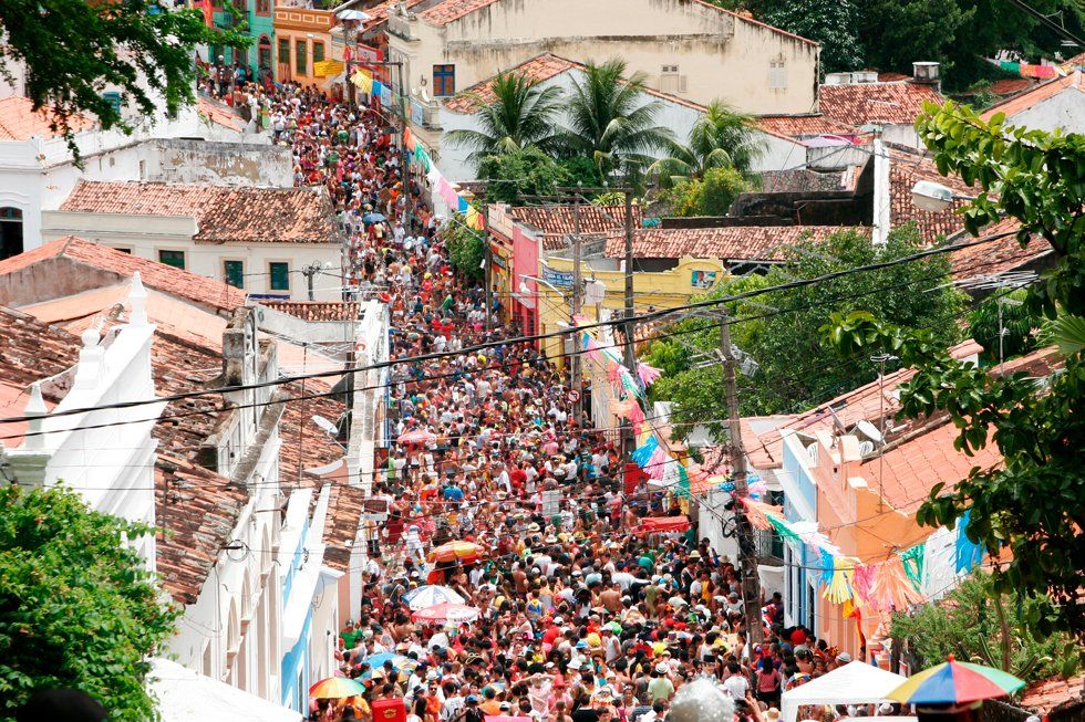 A crowd of people are walking down a street in a city.